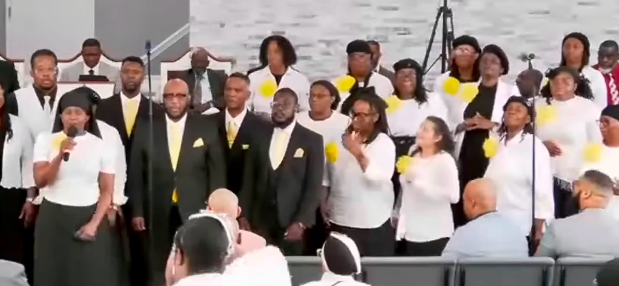A diverse gospel choir sings passionately in a church setting, wearing coordinated outfits with yellow accents. The image captures the energy of a worship performance.